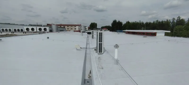 Membrana PVC na dachu magazynu — detal uszczelnienia wokół komina wentylacyjnego